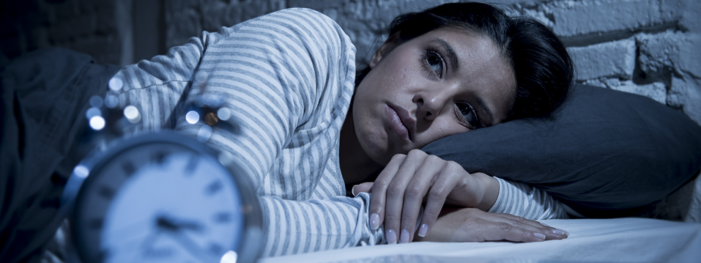 Image of woman looking sleepless with clock at the front 
