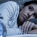 Image of woman looking sleepless with clock at the front